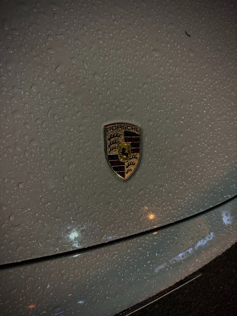 Porsche crest covered in raindrops